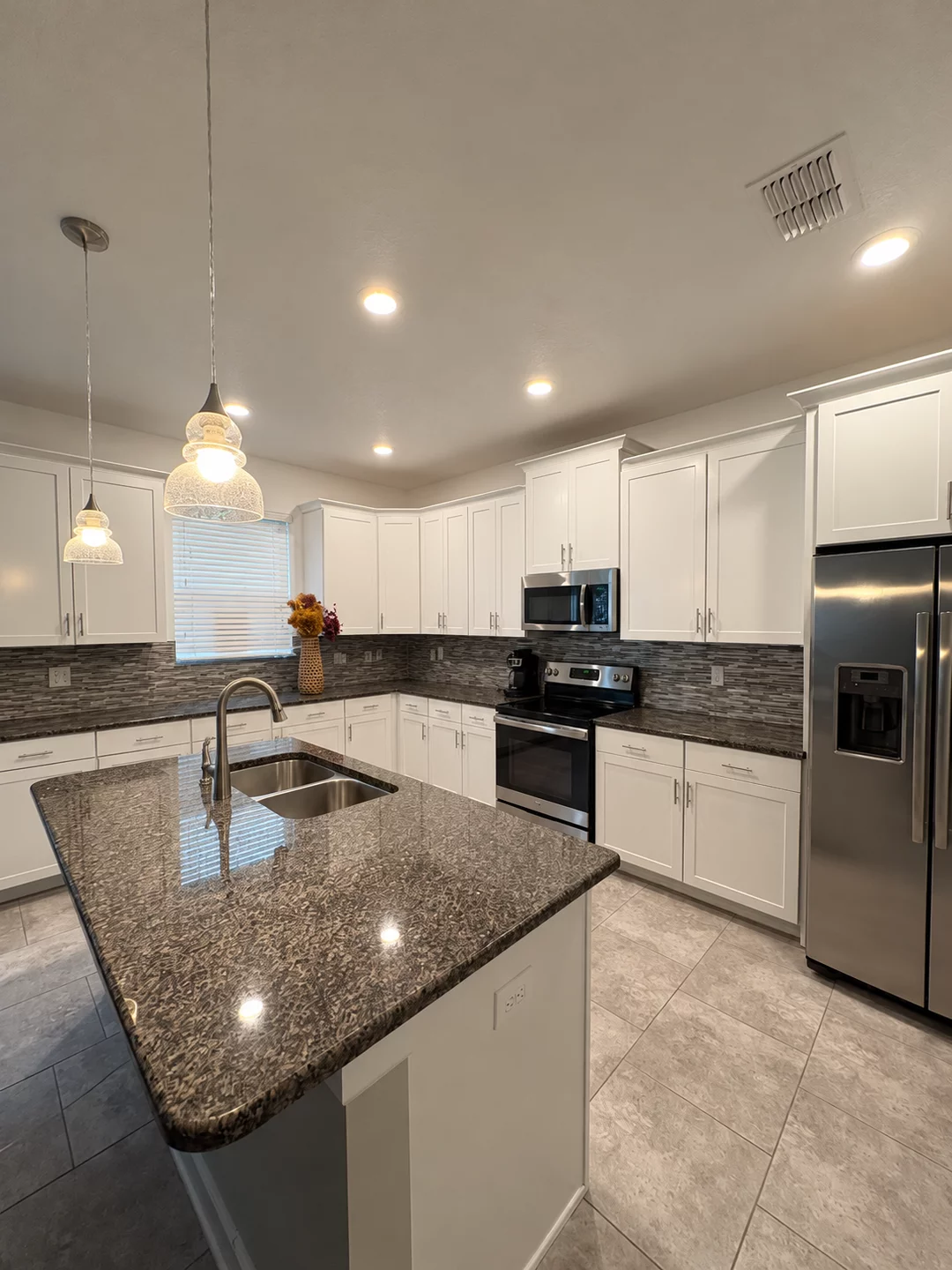Kitchen after refinishing, with bright white cabinets