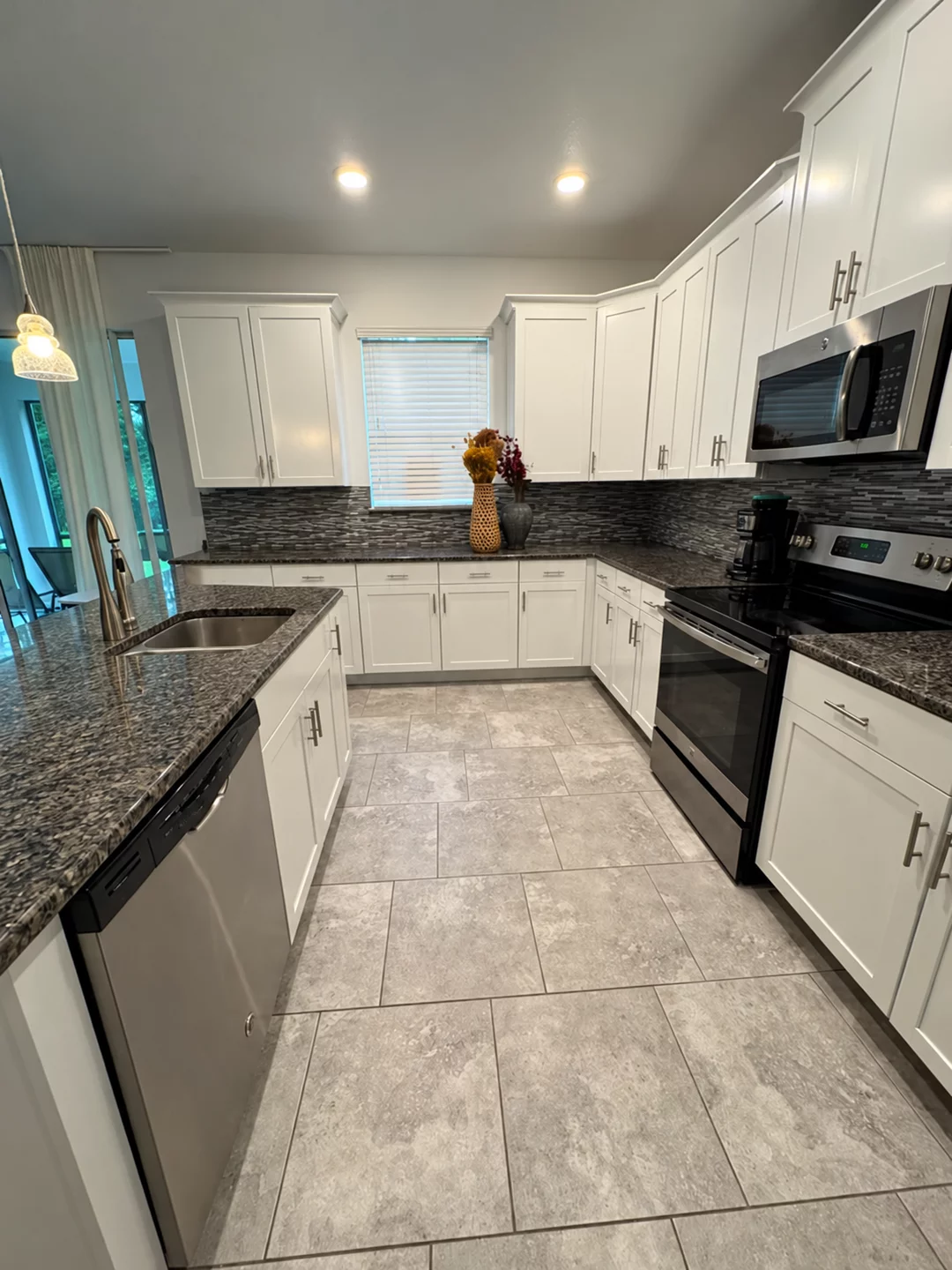 Refinished white kitchen cabinets viewed from the sink