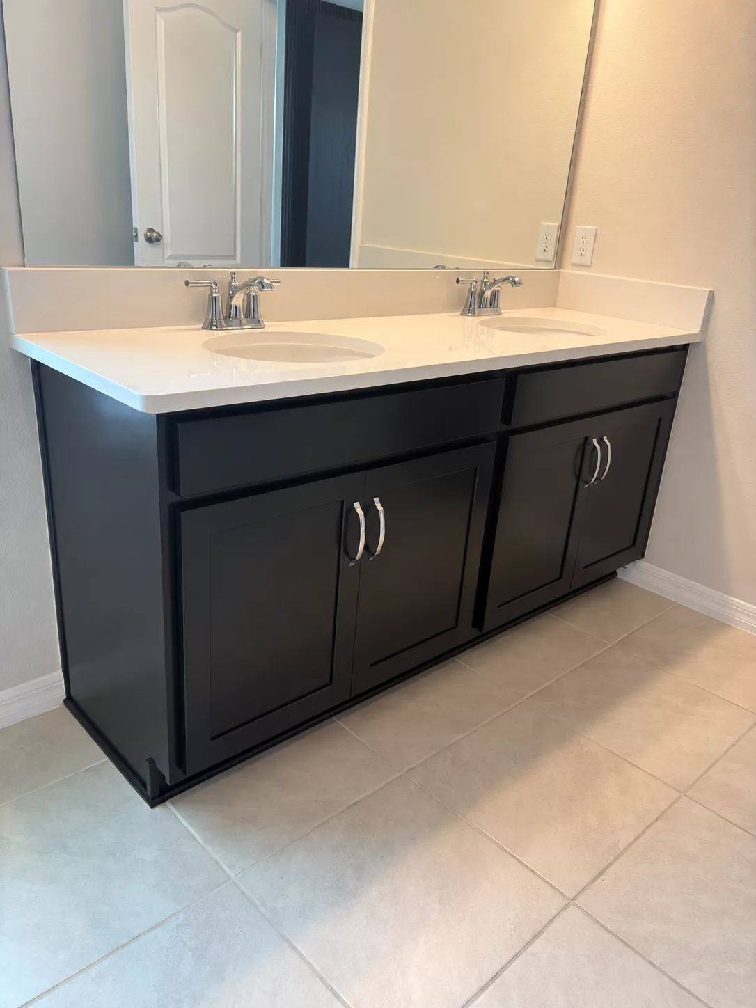Bathroom cabinet refinished in dark paint beneath a white countertop
