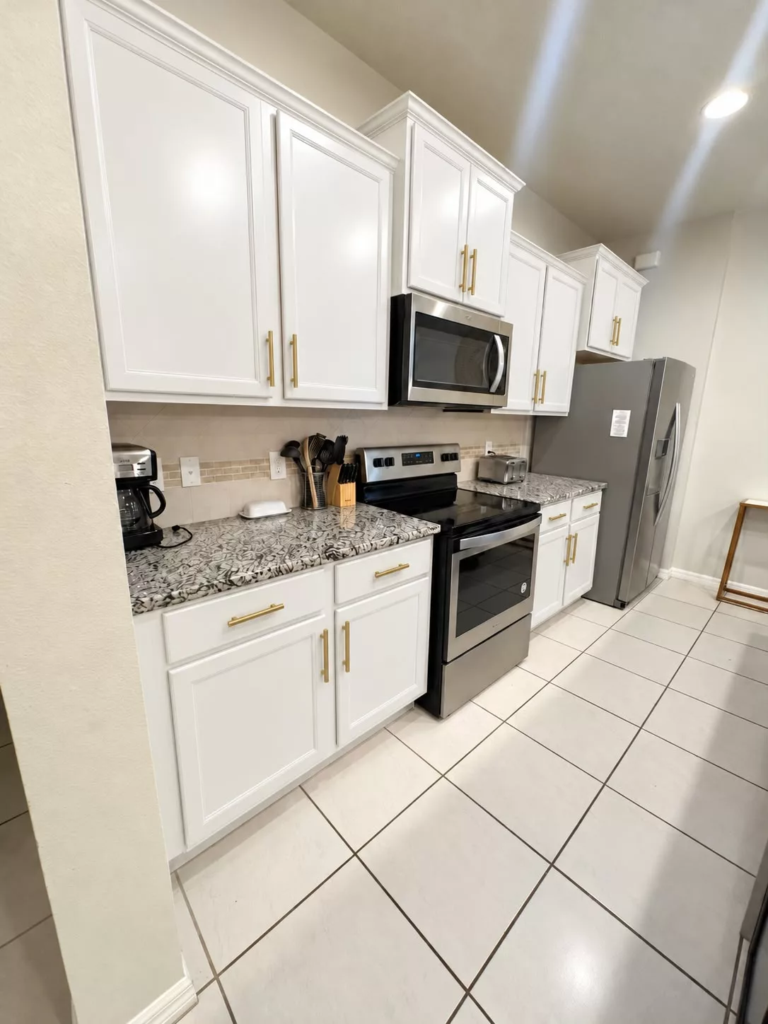 Fresh white kitchen cabinets with dark granite countertops
