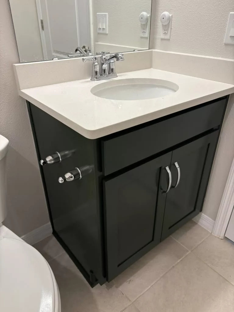 Refinished dark vanity doors beneath a white bathroom sink