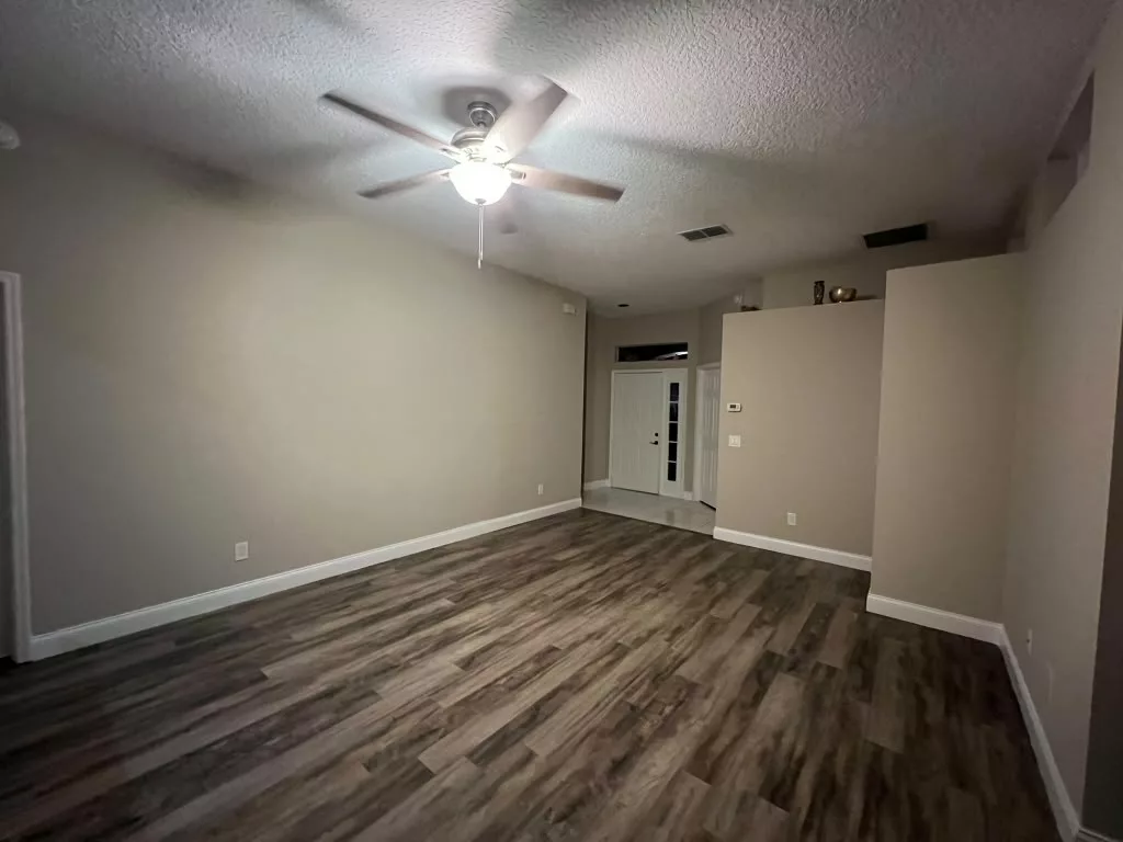 Living room with soft neutral painted walls and wood-look flooring